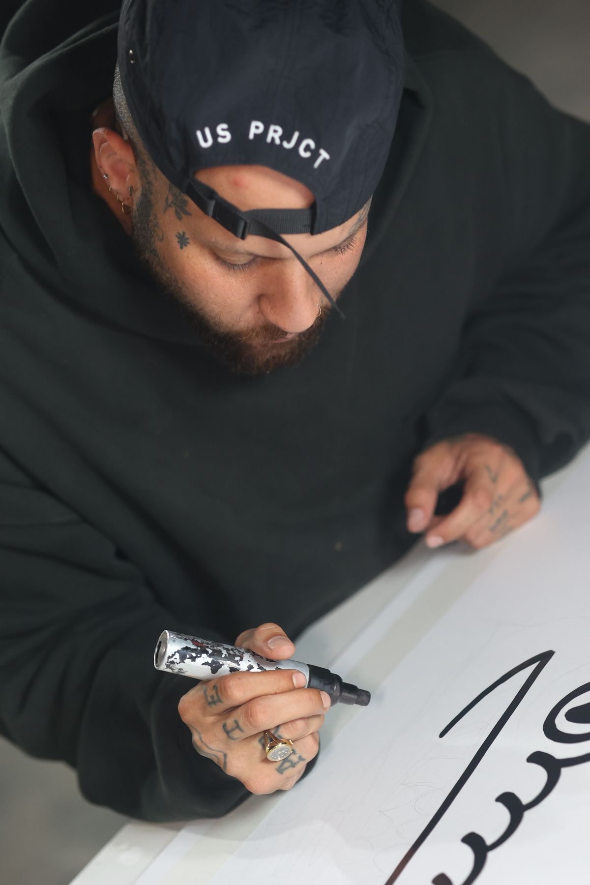 Ulises Malavé drawing flash designs by hand with a marker
